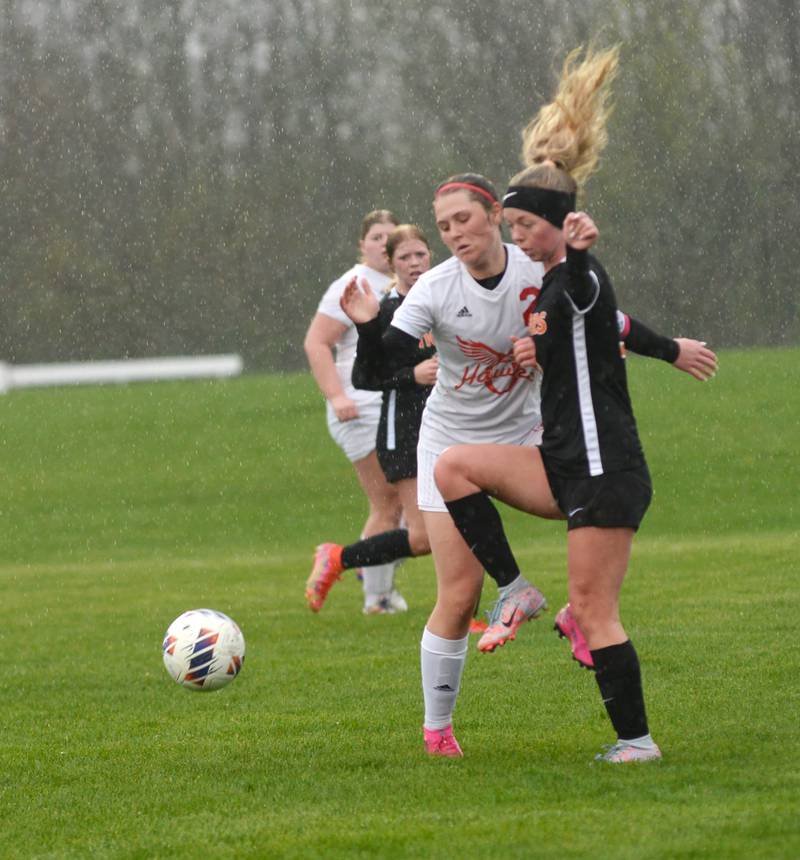 Oregon's Anna Stender (2) and Byron's Claire Hinnkel (5) battle for the ball as rain falls  on Thursday, April 18, 2024 at Byron High School.