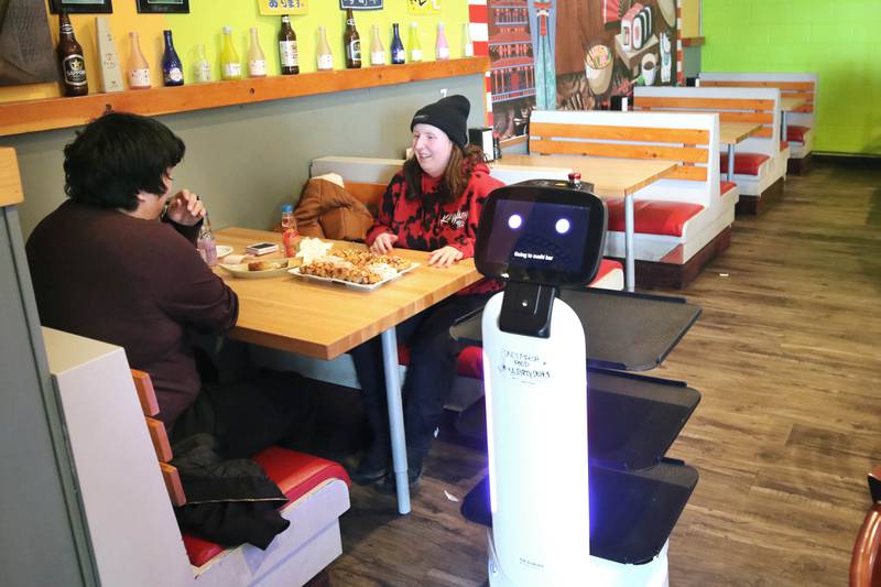 The robot waiter named Mushroom leaves a table at Fushi Yami hibachi and sushi restaurant in DeKalb after delivering an order Friday, Jan. 19, 2024, to David Salgado, from Chicago, and Rachael Iturbide, from Rochelle.