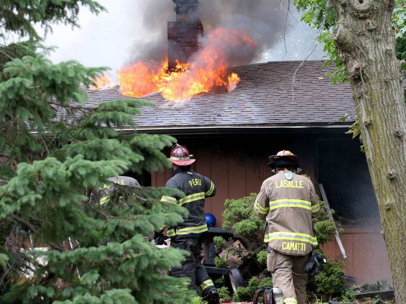 Firefighters work the scene of a fully-engulfed structure fire in the 500 block of North 2782nd Road on Monday, July 21, 2025 in La Salle. FIre departments from Utica, Wallace, Naplate, Spring Valley, Mendota, Troy Grove, La Salle, Peru, Oglesby and Tonica responded to the scene. Fire crews were dispatched at 9:45 a.m. La Salle Police and La Salle County Sheriff were also on the scene.