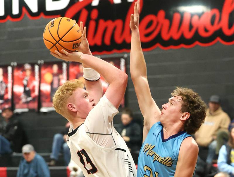 Indian Creek's Isaac Willis tries to shoot over Marquette’s Lucas Craig Monday, Dec. 9, 2025, during their game at Indian Creek High School in Shabbona.