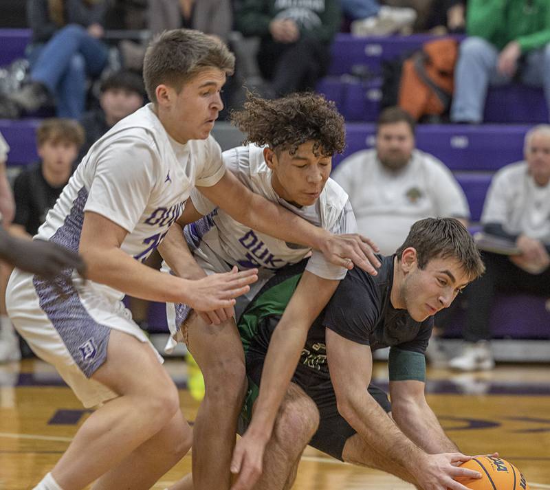 Dixon’s Cameron Foulker (left) and Armahn McGowan fight Alleman’s Jack Wendt for the ball Wednesday, Jan. 28, 2026.