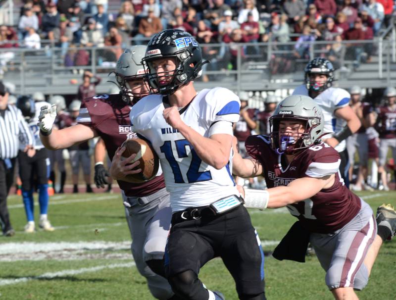 Eastland-Pearl City quarterback Adam Awender scrambles away from two Rockridge defenders in the 2A state football playoff's first round on Saturday, Nov. 2, 2024 at Eddington.