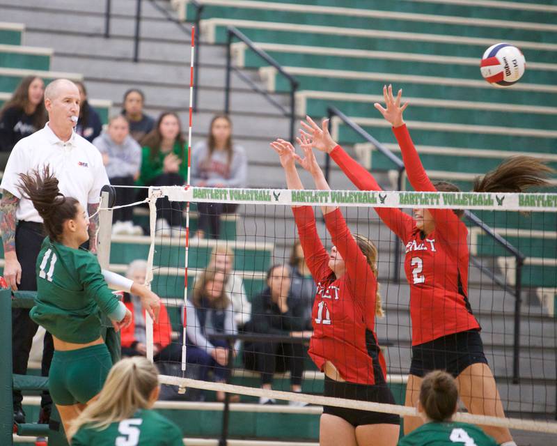 New Trier's Ana Vetter goes for the kill shot past Benet's Ellie Stiernagle (11) and Gabby Stasys (2) at the Class 4A Super Sectional Final on Friday, Nov.3,2023 in Bartlett.