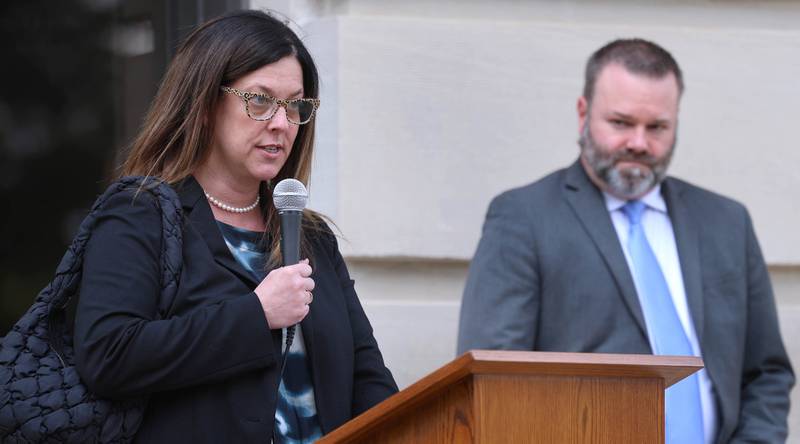 Prosecutor Jo Tracy, of the DeKalb County State's Attorney's Office, speaks as State's Attorney Riley Oncken looks on Wednesday, April 29, 2026, during Hands Around the Courthouse at the courthouse in Sycamore. The event was held to mark Child Abuse Prevention Month.