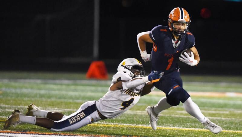 Joe Lewnard/jlewnard@dailyherald.com
Naperville North’s Cole Arl tries to break free from Neuqua Valley’s RJ Ugas during Friday’s game in Naperville.