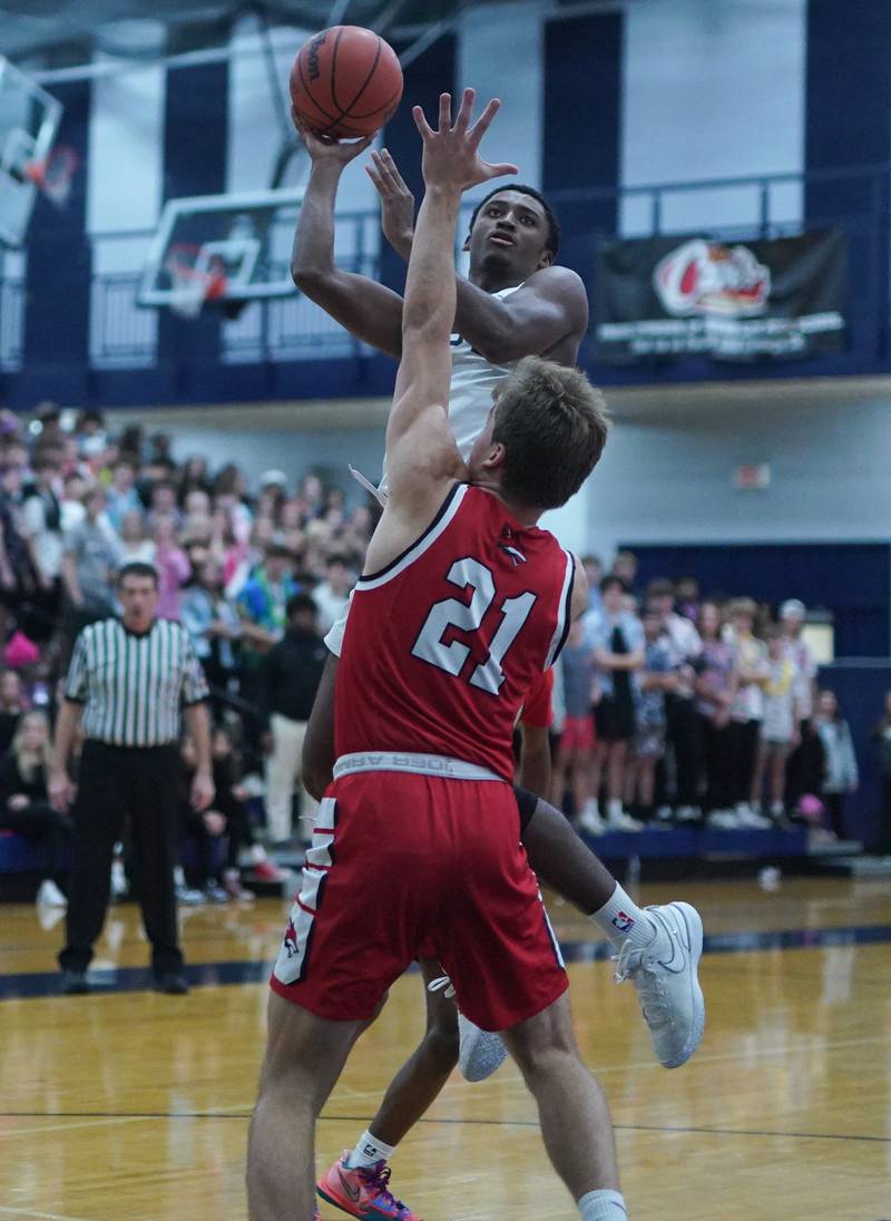 Oswego East's Andrew Wiggins (1) shoots the ball in the post over Yorkville's Taelor Clements (21) during a basketball game at Oswego East High School on Friday, Dec 8, 2023.