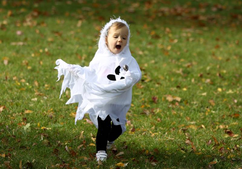Athena Kammerer, 1, runs in her ghost costume while trick-or-treating at Geneva businesses on Thursday, Oct. 27, 2022.