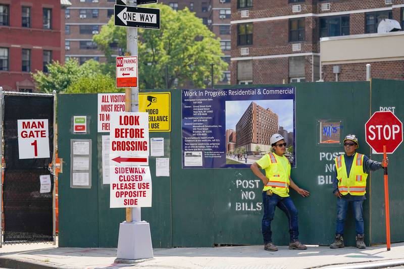 Construction workers help direct traffic outside a residential and commercial building under construction at the Essex Crossing development on the Lower East Side of Manhattan, Thursday, Aug. 4, 2022.  America’s hiring boom continued last month as employers added a surprising 528,000 jobs despite raging inflation and rising anxiety about a recession. (AP Photo/Mary Altaffer)