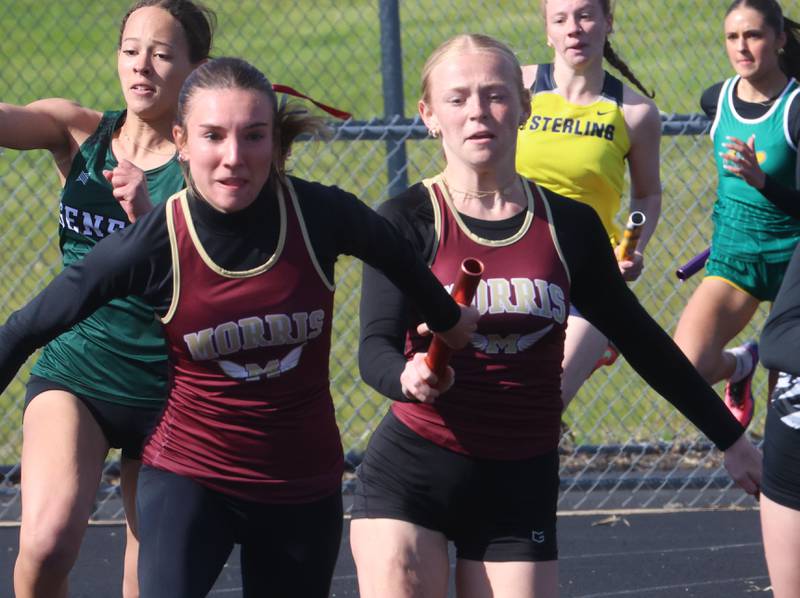 Morris's Ava Conley grabs the baton from Aniston Caputo in the 4x100 relay during the Class 2A Sectional track meet on Wednesday, May 13, 2026 in the Jeff Prusator Athletic Complex at Mendota High School.