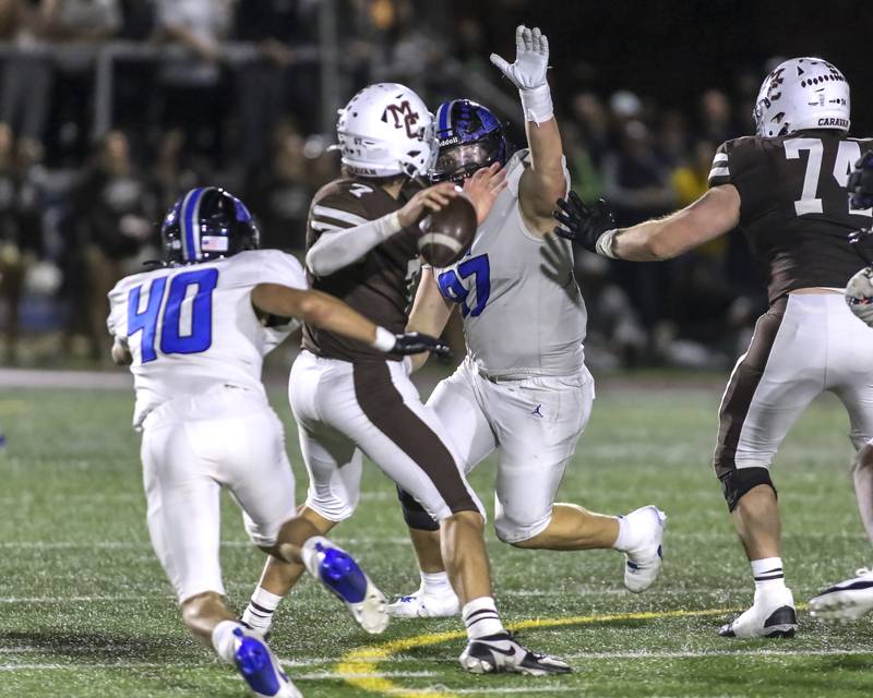 Lincoln-Way East's Gage Ladere (97) and Edan Evans (40) converge on Mount Carmel's Emmett Dowling (7) as he attempts a pass during Class 8A quarterfinal football game between Lincoln-Way East at Mount Carmel. Saturday, Nov 15, 2025 in Chicago.