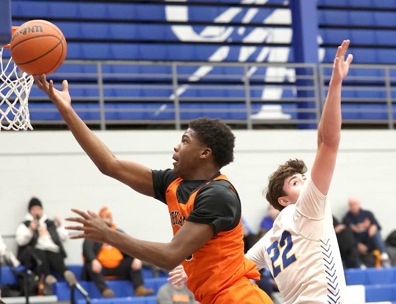 DeKalb’s Davon Grant goes by Lyons Township's Brady Chambers for a layup Monday, Jan. 15, 2023, during their game in the Burlington Central Martin Luther King Jr. boys basketball tournament.