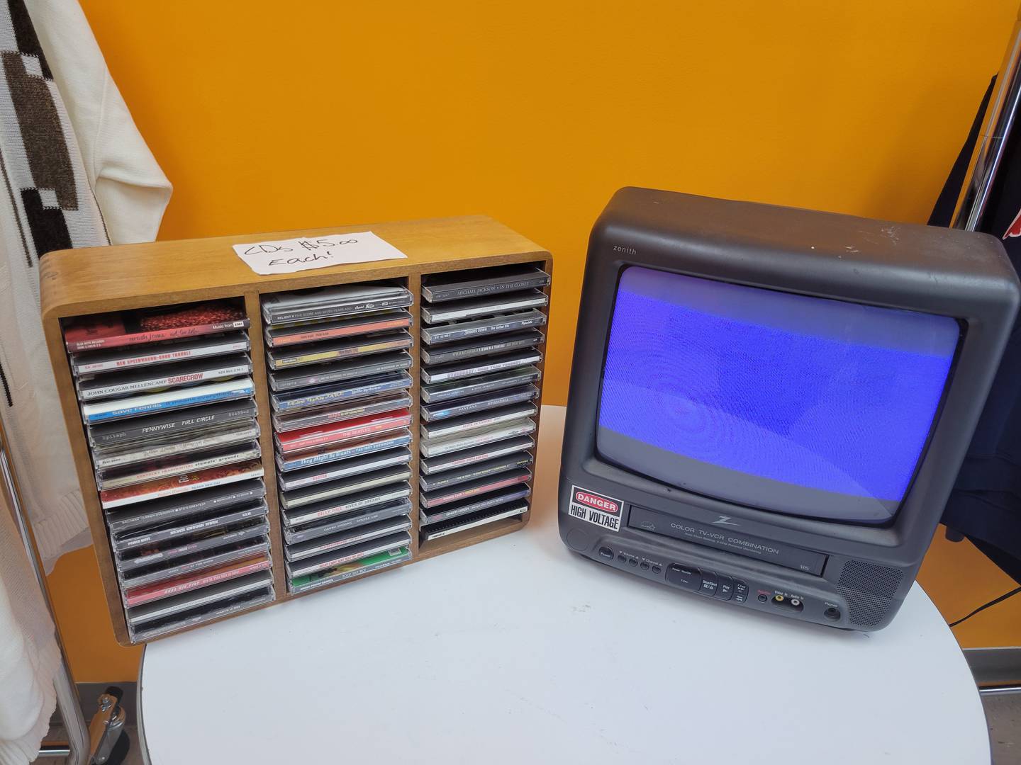 A selection of CDs for sale is displayed next to an old TV set at Glue Man Vintage & Records in Bourbonnais during the store's grand opening May 16, 2025.