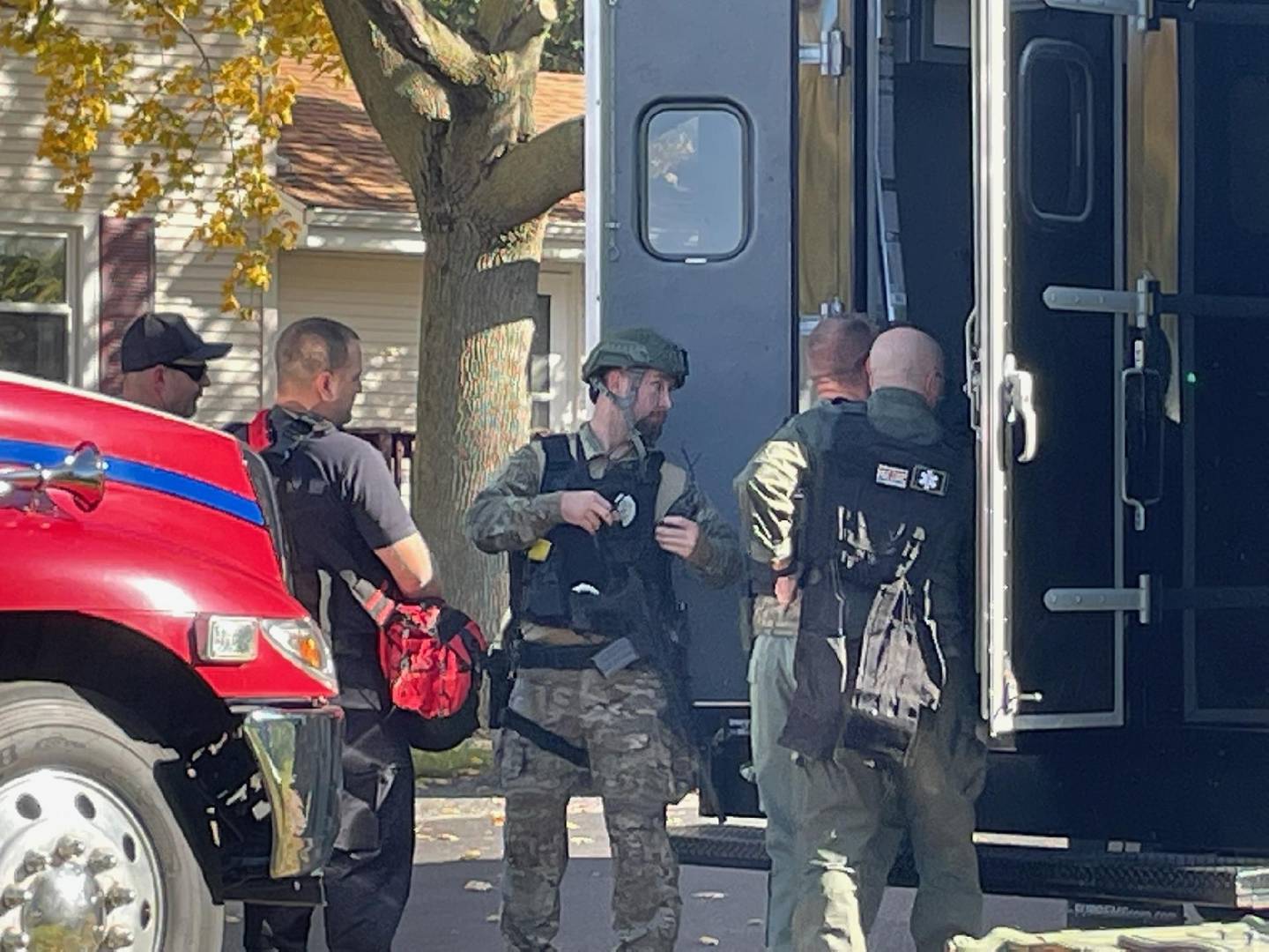 A special weapons and tactical team dons gear near an unmarked command van that has arrived on the scene of a standoff between a suspected gunman and law enforcement on Saturday, Oct. 22, 2022, in Sheridan.