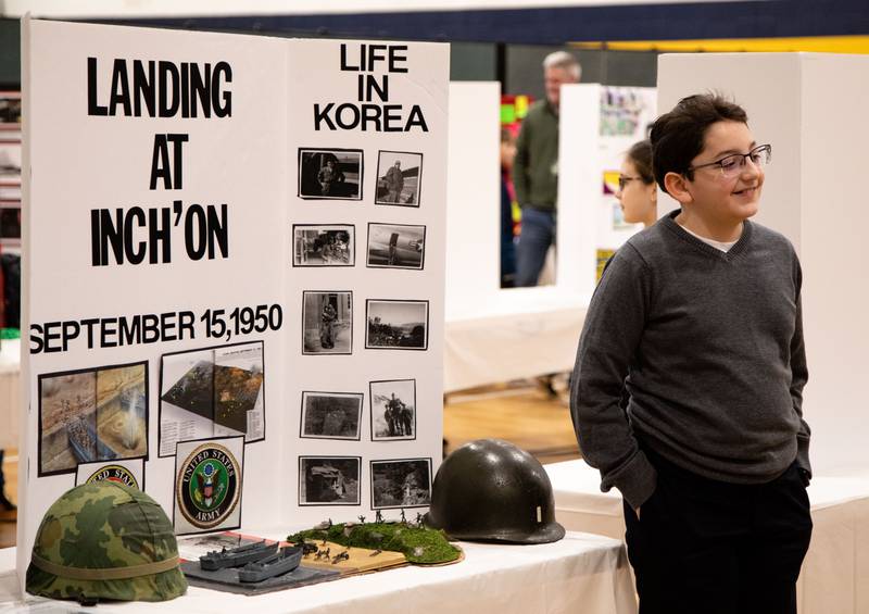 A fifth grader stands next to his project on the Korean War operation, Landing at Inch’on, during Saint Mary of Gostyn School's Open House in Downers Grove on Sunday, Jan. 29, 2023.