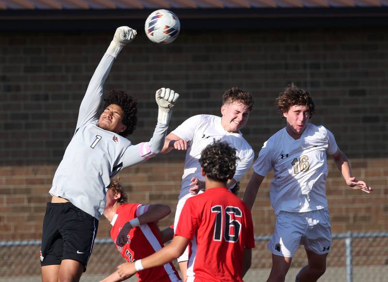 Yorkville keeper Caleb Reveter punches the ball away from Sycamore's Tyler Hiland and Maddux McLaughlin on a corner kick Thursday, Aug. 28, 2025, during their game in the Barb Cup tournament at DeKalb High School.