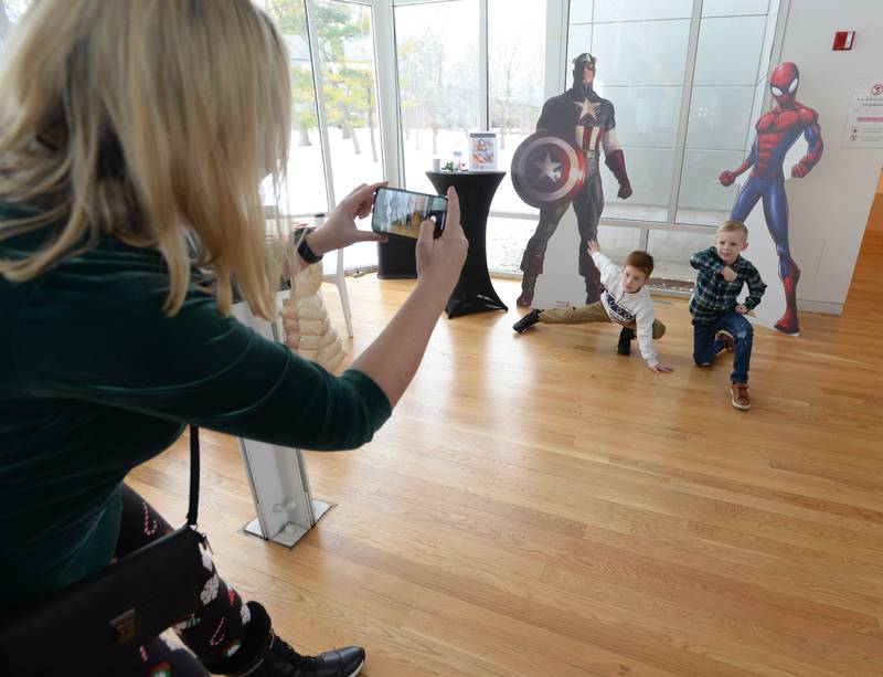 Tamara Djurdjevic of Elmhurst takes a picture of her son (left) Mikailo and his friend Shane Palmer of Elmhurst being superheroes while attending the Family Holiday Party at the Art Museum Saturday Dec 17, 2022.