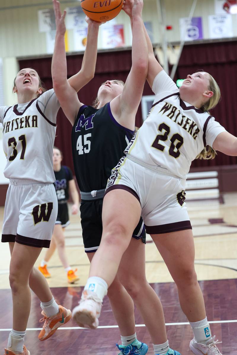 Manteno's Emily Horath, center, reaches for a rebound against Watseka/Milford's Noelle Schroeder, right, and Thayren Rigsby during Manteno's 57-52 victory on Wednesday, Jan. 21, 2026.