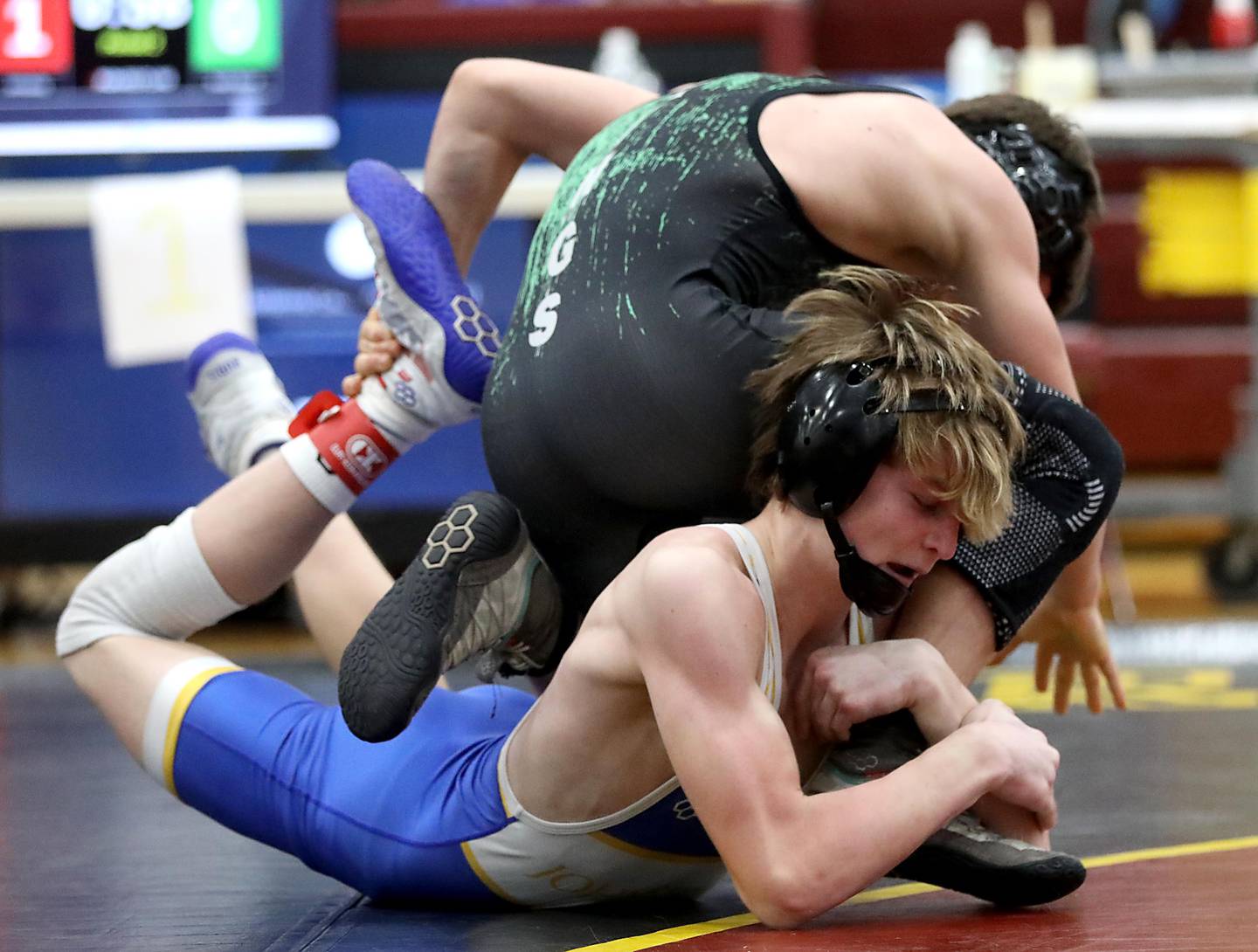 Johnsburg’s Chase Vogel hangs on to foot of North Boone’s Gabe Marella during a120-pound match in the Tom DuBois Invite wrestling meet on Saturday, Dec. 13, 2025, at Richmond-Burton High School in Richmond.