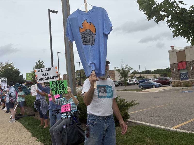 Dave Kozlowski holds up a shirt during a protest against President Trump July 26, 2025 in McHenry.