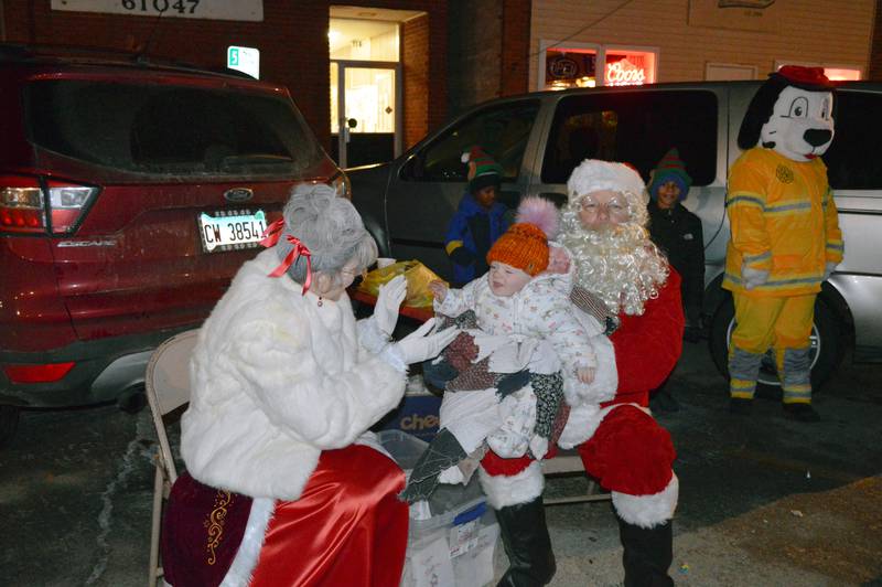 Alice Lamping, 10 months, of Suffolk, England, sits with Santa and Mrs. Claus during the Leaf River Christmas festival on Dec. 17. Alice's father, Mickey Lamping, originally of Leaf River, is stationed in England for the U.S. Air Force.