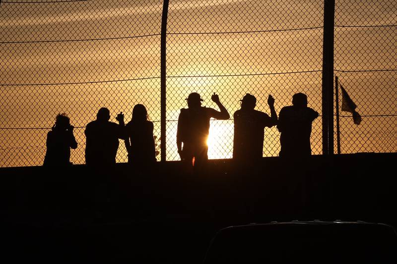 Race fans line the fence to watch one of the heat races at Grundy County Speedway on June 15, 2024 in Morris.