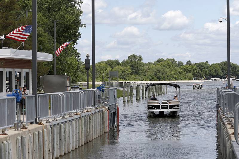 Pontoon boats enter the locks during a completion celebration of the $22 million improvement project of the Stratton Lock and Dam, 2910 State Park Road, in McHenry, on Wednesday, July 13, 2022. The dam, that is operated by Illinois Department of Natural Resources’s Office of Water Resources, to help ensure safe and efficient recreational boating on the Fox River Chain of Lakes. Close to 20,000 watercraft pass through the lock during the boating season.