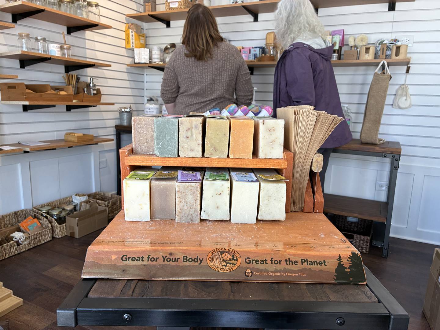 Store owners Kelly Smith, left, and Jodi Stone, check out some of Stone's products on Sunday, April 26, 2026, at McHenry's Riverwalk Shoppes. The shops open for the season at 9:30 a.m. Friday, May 1.