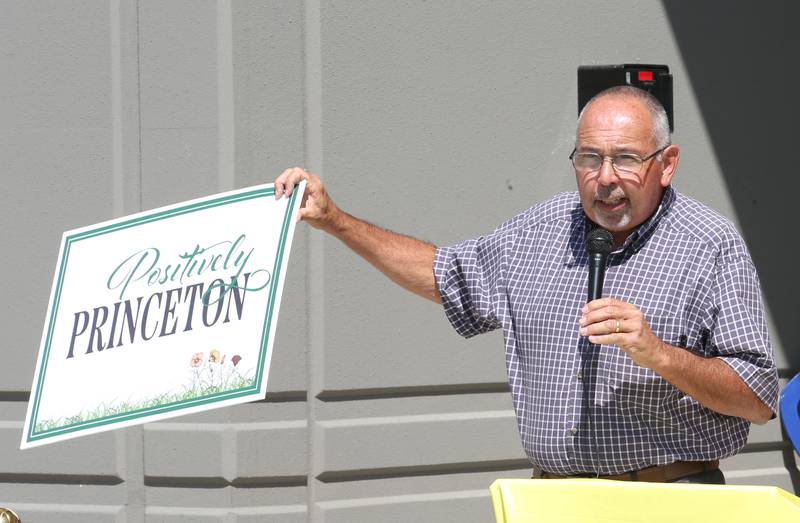Princeton mayor Ray Mabry, holds a sign to present to Ollies Bargain Outlet during the grand opening celebration on Wednesday, Aug. 21, 2024 in Princeton. Gathered at the ceremony were about 50 people. The new distribution center is 615,000 square foot, which is about the equivalent of 11 football fields. It will serve 150 stores in the Midwest. The cost of the project is 68 million. that says "Positively Princeton while giving a speech during the Ollies Warehouse Bargains distribution grand opening on Wednesday, Aug. 21, 2024 in Princeton. Gathered at the ceremony were Brian McNabb Ollie's senior vice president and Princeton Mayor Ray Mabry. The new distribution center is 615,000 square foot, which is about the equivalent of 11 football fields. It will serve 150 stores in the Midwest. The cost of the project is 68 million.