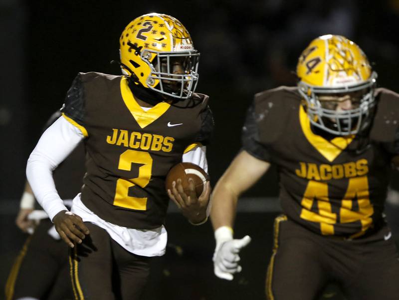 Jacobs' Antonio Brown looks to run behind his teammate Paulie Rudolph during a IHSA Class 7A first round playoff football game Friday, Oct. 28, 2022, between Jacobs and Brother Rice at Jacobs High School in Algonquin.