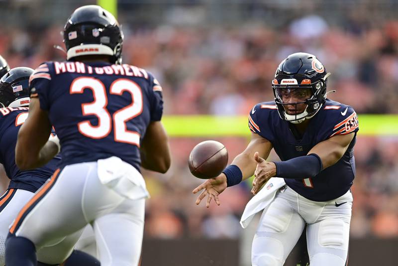 Chicago Bears quarterback Justin Fields pitches out to running back David Montgomery during the first half against the Cleveland Browns, Saturday, Aug. 27, 2022, in Cleveland.