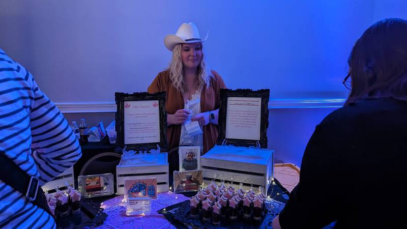 Christine Whitmer, owner of Sweet Swirls Bakery in Manhattan, serves chocolate treats at at the Shorewood HUGS annual chocolate ball fundraiser on Saturday, Feb. 3, 2024, at the  Posh Banquets & Event Center in Joliet. The fundraiser's theme this year was "Nashville Nights."