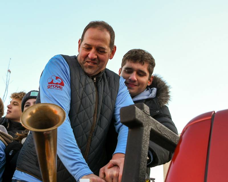 Chris Jonson, who owns Tivoli Theater, and his son, Kyle, help start the Grove Express 5k in downtown Downers Grove on Thursday Nov 23, 2023, and honor Chris’s dad Willis Johnson who also owns the Tivoli Theater.
