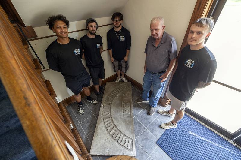 Movers Kayton Westmorland (left), Devin Zinke, Rayce Gale, janitor Ken Heerdt and moving business owner Eric Brunson stand with the heavy stone plaque Thursday, Sept. 19, 2024, at First United Methodist in Sterling.