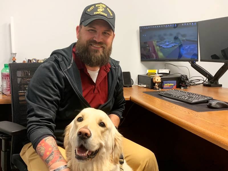 Ty Watson, a Veteran Services Officer with the Veterans Assistance Commission of Kankakee County's , poses for a photo with his 3-year-old therapy dog, Maverick, a golden retriever, at the Bourbonnais office.