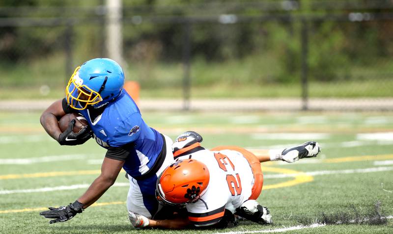 Simeon’s Andre Crews is taken down by Wheaton Warrenville South’s Connor Silwa during a game at Gately Stadium in Chicago on Saturday, Aug. 27, 2022.
