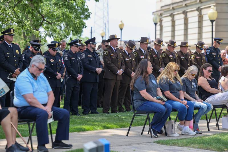 Officers bow their heads in a moment of silence alongside family and friends of fallen officers during the annual Law Enforcement Officers Memorial Ceremony honoring Kankakee County officers, held on the lawn of the Kankakee County Courthouse on Thursday, May 15, 2025.
