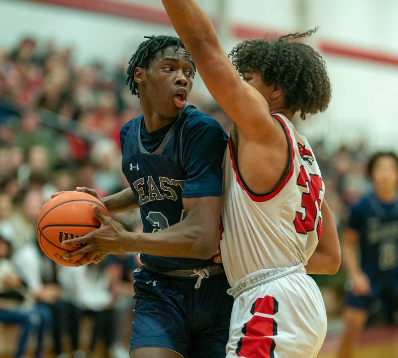 Oswego East's Mekhi Lowery (24) posts up against Yorkville's LeBaron Lee (35) during a basketball game at Yorkville High School on Friday, Feb 3, 2023.