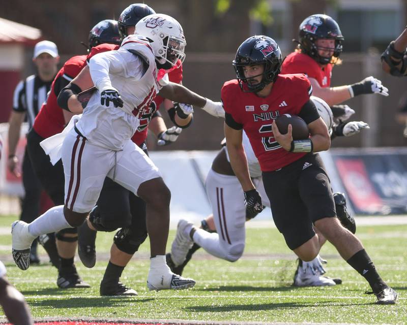 Northern Illinois Huskies quarterback Ethan Hampton, right, runs the ball during the game on Saturday Oct. 5, 2024, while taking on Umass held at Huskie Stadium in DeKalb.