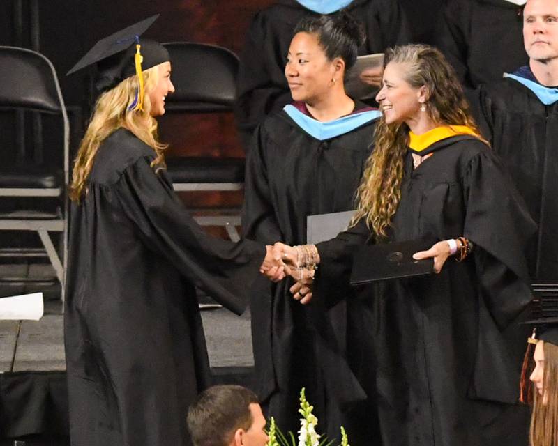 A St. Charles East graduate accepts her diploma on Monday, May 18, 2026, during commencement at the Convocation Center in DeKalb.