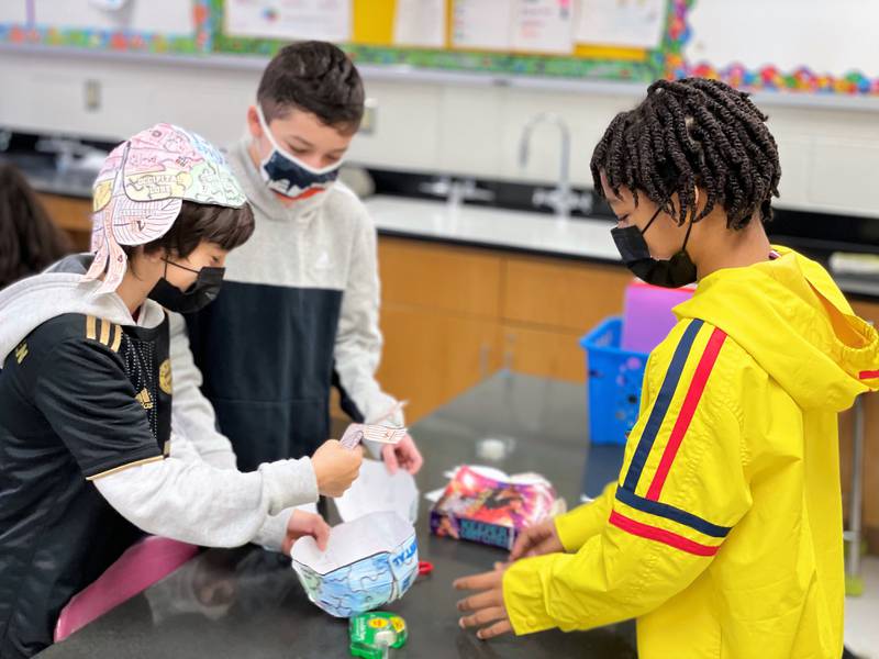 John F. Kennedy Middle School seventh graders Giovanni Paz, Armando Medina, and Kevin Killins (left to right) are wearing their brains on the outside of their heads! In a fun and engaging hands-on activity, students in Madonna Majka’s science class create a brain hat as they apply their knowledge of the anatomy of the human brain on Tuesday, January 11, 2022. Plainfield School District 202 said in a message  to families on Sunday that masks are “strongly encouraged” but will not  be required for students, staff or visitors until further notice.