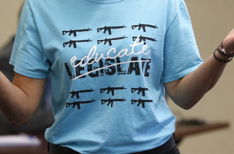 Tonya Franklin wears a T-shirt expressing her opinion as she addresses the McHenry County Law and Government Committee on Tuesday, Jan. 31, 2023, at the McHenry County Administration Building in Woodstock. The committee held a public comment period before it considered a resolution to oppose Illinois' new gun ban and support its repeal.