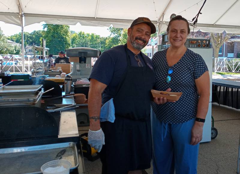 Bernie and Cindy Laskowski, owners of Craft Urban in Geneva, serve up burgers and Korean barbecue in the Flavor Fare tent during Geneva’s Festival of the Vine on Friday. The festival continues on Saturday and Sunday with food,