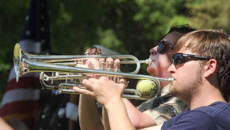 Oswego High School's Andrew Sniegowski (front) and Oswego East's Evan Wille play Taps at the Townwhip Cemetery during the annual Memorial Day Parade and Service, Monday, May 29, 2023.