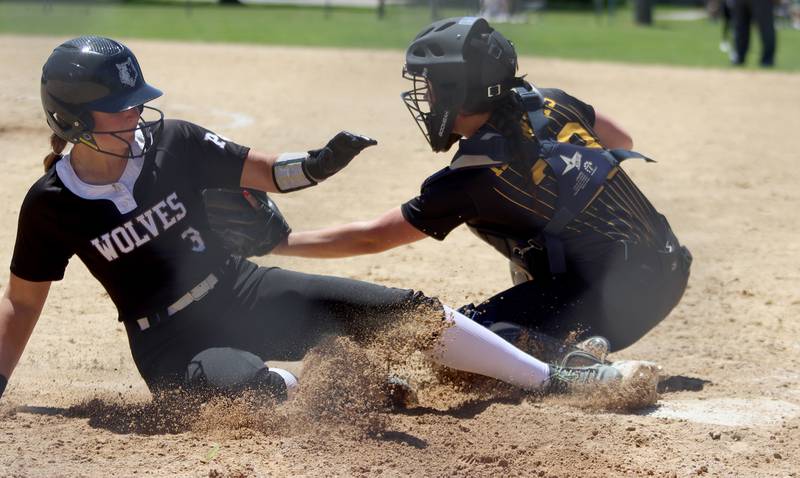 Prairie Ridge’s Autumn Ledgerwood, left, slides safely under as Harvard’s Britta Livdahl fields the throw during Class 3A softball regional final action at Lions Park in Harvard Saturday.