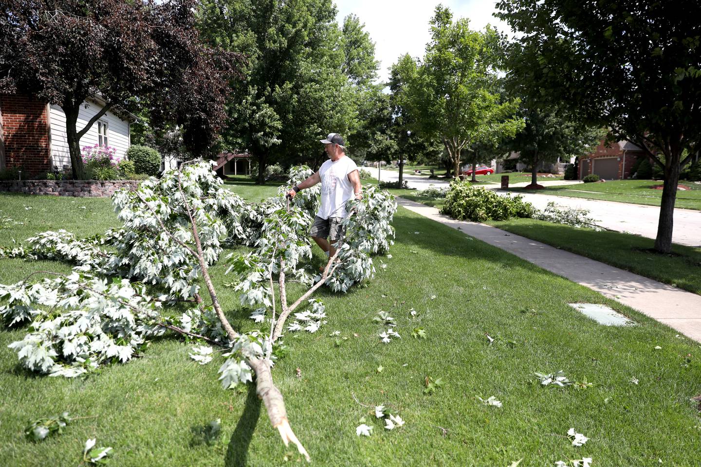 Rob Dzimek of North Aurora clears a large branch out of the yard of his parents’ Sugar Grove home following a storm the evening of Monday, July 15, 2024.