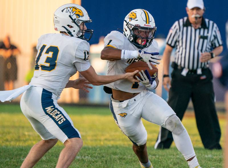Neuqua Valley's Mark Mennecke (13) hands the ball off to Jaden Mcgee (1) during a football game against Oswego at Oswego High School on Friday, Aug 26, 2022.