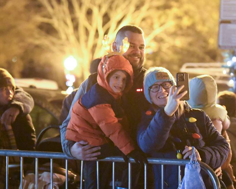 Yorkville family members Nathan Cooling,5, Adam Cooling and Abby Cooling take a selfie together as the parade starts on Friday Nov. 21, 2025, that took place before the tree lighting ceremony held at Riverfront Park in Yorkville.