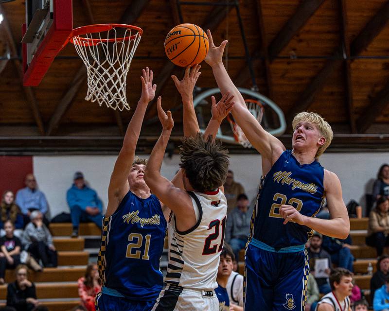 Henry-Senachwine's Carson Rowe (21) lays up ball as Marquette's Luke McCullough (23) blocks shot on Friday, Feb. 13, 2026 at Henry-Senachwine High School in Henry.