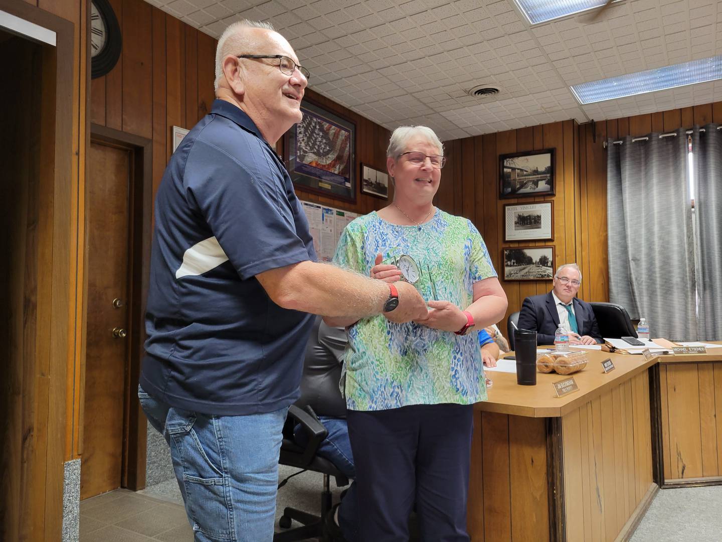 Marseilles Library director Jan Ambrose (right) on Wednesday accepts a gift from Mayor Jim Hollenbeck as a token of esteem for her years of service to the city. Ambrose will be retiring later this month after 23 years in that post.
