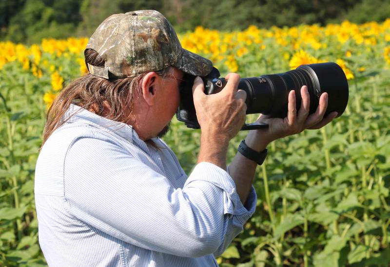 Ron Floyd, from Green Bay, takes photos Friday, July 14, 2023, in one of the fields at Shabbona Lake State Recreation Area in Shabbona Township.